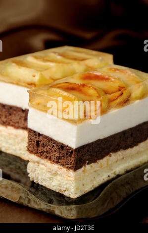 Kuchen aus Karamell, Apfel Mousse, Schokolade und Mandeln Biskuit mit einer Schicht Gelee karamellisiertem Apfel Scheiben gestapelt Stockfoto