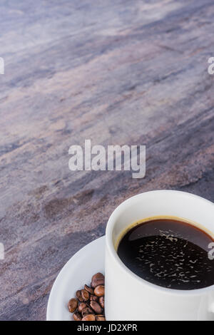 Black Coffee in einer weißen Tasse und Kaffee wurde auf die graue Holztisch mit Textfreiraum Stockfoto