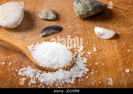 Nahaufnahme von Meersalz in Holzlöffel über Holz Hintergrund Stockfoto