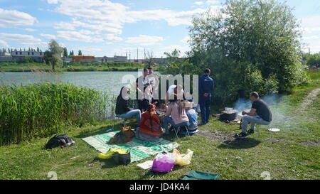 Kursk, Rußland - June1, 2017: Gruppe von Freunden mit Picknick in einem Park an einem sonnigen Tag - Menschen hängen, Spaß beim Grillen und entspannen. Stockfoto