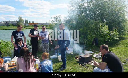 Kursk, Rußland - June1, 2017: Gruppe von Freunden mit Picknick in einem Park an einem sonnigen Tag - Menschen hängen, Spaß beim Grillen und entspannen. Stockfoto