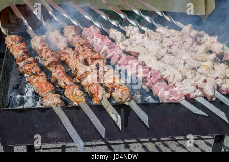 Marinierte Schaschlik vorbereiten auf ein Barbecue-Grill auf Holzkohle. Schaschlik oder Schaschlik in Osteuropa beliebt. Schaschlik aufgespießt Fleisch wurde ursprünglich Stockfoto