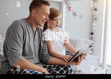 Emotionale Mädchen und ihren Eltern sitzen auf dem Bett Stockfoto