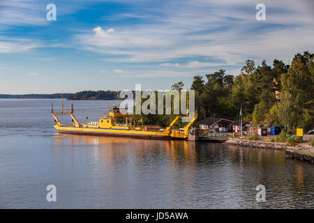 VAXHOLM, Schweden - 15. September 2016: Kleine gelbe Ro-Ro-Fähre geht in der Nähe von mittelalterlichen Stadtbefestigung von Oscar Fredriksborgs. Wahrzeichen von Stockholm Arhipels Stockfoto