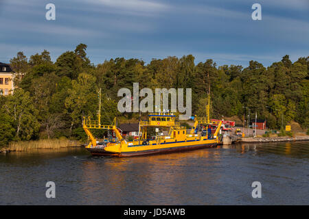 VAXHOLM, Schweden - 15. September 2016: Kleine gelbe Ro-Ro-Fähre geht in der Nähe von mittelalterlichen Stadtbefestigung von Oscar Fredriksborgs. Wahrzeichen von Stockholm Arhipels Stockfoto