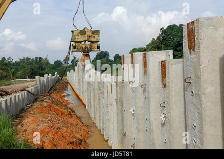 Ramm-Maschine arbeitet mit einer Brückenkonstruktion Haufen. Stockfoto