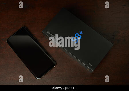 New York, USA - Juni 13, 2017:Samsung s8 plus Smartphone und Box lag auf dunklen braunen Holztisch Ansicht von oben Stockfoto