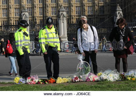 Polizisten und Mitglieder der Öffentlichkeit Blumen in Gedenken an PC Keith Palmer und die anderen Opfer des London-Terror-Anschlag dargelegt. Stockfoto