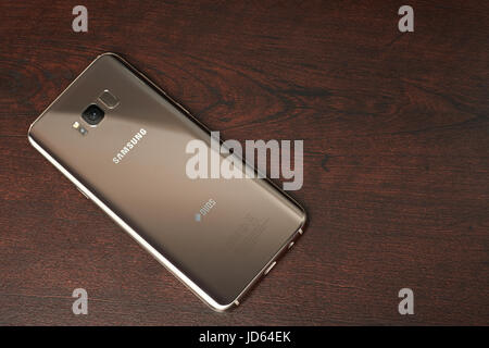 New York, USA – 13. Juni 2017: Gold Farbe Samsung s8 plus Smartphone lag auf dunklen braunen Holztisch Ansicht von oben Stockfoto