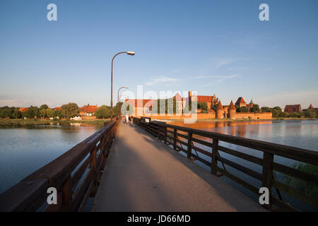 Marienburg bei Sonnenuntergang in Polen, Blick von St. Adalbert Fußgängerbrücke über Fluss Nogat, Deutsche Orden mittelalterliche Festung Stockfoto