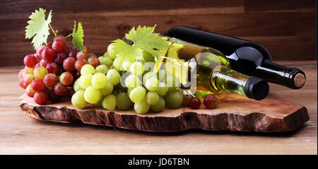 Flasche von weißen und roten Wein, Traube und Korken auf Holztisch Stockfoto