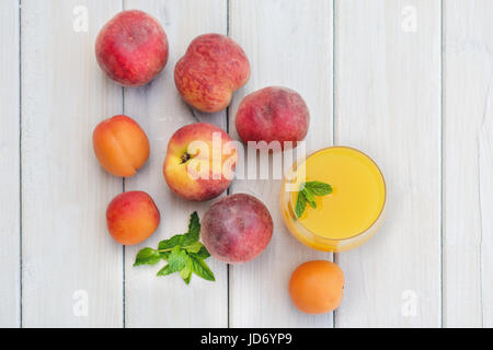 Komposition mit Aprikosen und Nektarinen auf einem weißen Tisch Stockfoto