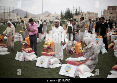 Sanaa, Jemen. 19. Juni 2017. Jemenitischen Männer sammeln eine Spende Hilfe durch die Regierung von Kuwait in Sanaa, Jemen, 19. Juni 2017. Unvermindert Konflikt und rasch verschlechternden Bedingungen in Jemen drängen Millionen vertriebenen Jemeniten weiter in Gefahr und Not. Seit Beginn des Konflikts im März 2015, wurden mehr als 11 Prozent der Yemen·s Bevölkerung, einige 3 Millionen Menschen gezwungen, ihre Häuser aus Sicherheitsgründen zu verlassen. Bildnachweis: Dpa picture Alliance/Alamy Live News Stockfoto