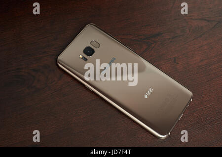 New York, USA – 13. Juni 2017: Ahorn gold Farbe Samsung s8 + Smartphone lag auf dunklen braunen Holztisch Ansicht von oben Stockfoto