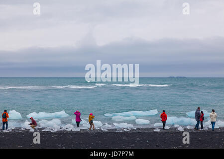 Touristen auf der Suche auf die Eiskristalle aus der Gletscherlagune Jökulsárlón in Island Stockfoto