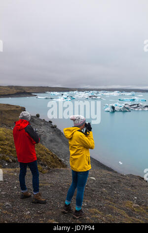 Touristen fotografieren der Eisberge in der Gletscherlagune Jökulsárlón in Island Stockfoto