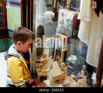 Ein Junge (5 Jahre alt) Suchen in im Fenster eines Toy Shop in die Royal Arcade, Norwich, Norfolk, England