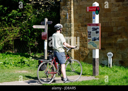 Ein Mann auf einem Fahrrad an der Bakewell Information Board am alten Bakewell Station auf dem monsal Trail in Derbyshire, England Stockfoto