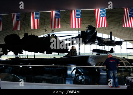 Duxford Air Museum in Cambridgeshie, England. Die Sonne leuchtet die Stars & Stripes im American Air Museum mit der F-15 Eagle darüber hinaus. Stockfoto