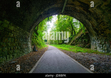 Leere Tunnel mit Steinmauern und Blick auf Straße durch Torbogen, Belgien. Belgien-Europa Stockfoto