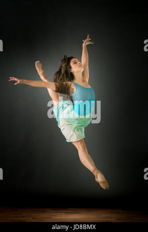 Weiblichen Balletttänzer springen Luft, Arme ausgestreckt, Studio gedreht. Kaukasische passen sportliche ziemlich mager Stockfoto