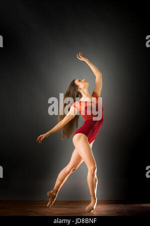 Weiblichen Balletttänzer lehnt sich zurück auf der Suche mit Arme ausgestreckt, Studio gedreht. Kaukasische passen sportliche ziemlich mager Stockfoto