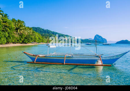 Traditionelle Banca Boot in klarem Wasser am Corong Sandstrand in El Nido, Philippinen. Stockfoto