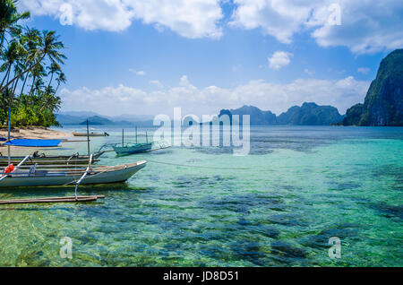 Banca Boote im klaren Wasser am sandigen Strand in El Nido, Philippinen. Stockfoto