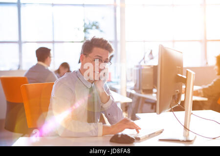 Jungunternehmer-Programmierer in großes helles Büro bei der Arbeit mit computer Stockfoto