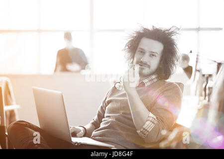 Jungunternehmer-Programmierer in großes helles Büro bei der Arbeit mit computer Stockfoto
