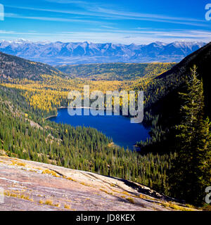 Gletscher See und Herbst Lärche in den Mission-Bergen über das Swan Valley, mit dem Schwan in der Ferne in der Nähe von Condon, montana Stockfoto