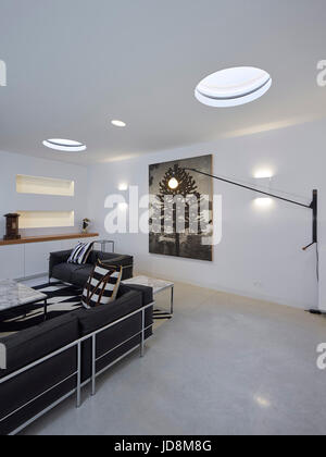 Innenansicht im Keller mit Corbusier Sofa und Potenz Lampe von Jean Prouvé. Notting Hill House, London, Vereinigtes Königreich. Architekt: Michaelis Boyd A Stockfoto