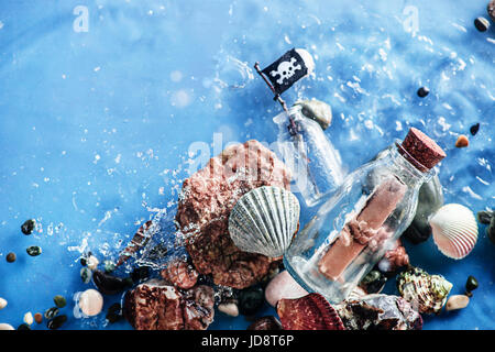 Piraten-Nachricht in einer Glasflasche im flachen Wasser mit Wellen von Seawave. Still-Leben unter Wasser. Stockfoto