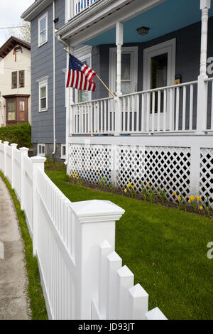 amerikanische Flagge von Veranda Holzhaus und weißen Kunststoff Lattenzaun Dorchester Boston USA Stockfoto