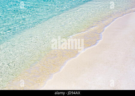 Schöner Strand mit sanften Wellen und kristallklarem Wasser entspannen Stockfoto