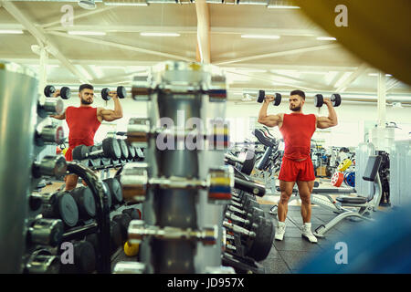 Bodybuilder mit Hanteln Übungen im Fitness-Studio Stockfoto