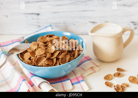 Gesundes Frühstück mit Weizen Buchweizen-Kleie-Müsli mit Milch in blauen Keramikschale. Verzehrfertige Stockfoto