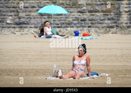 Sonnenanbeter am Strand von Barry Island, South Wales, wo Temperaturen in den hohen zwanziger Jahren sind und Menschen strömen in das Meer, das herrliche sonnige Wetter zu genießen. Stockfoto