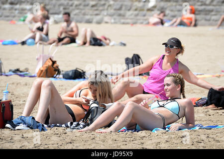 Sonnenanbeter am Strand von Barry Island, South Wales, wo Temperaturen in den hohen zwanziger Jahren sind und Menschen strömen in das Meer, das herrliche sonnige Wetter zu genießen. Stockfoto