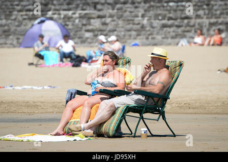 Sonnenanbeter am Strand von Barry Island, South Wales, wo Temperaturen in den hohen zwanziger Jahren sind und Menschen strömen in das Meer, das herrliche sonnige Wetter zu genießen. Stockfoto