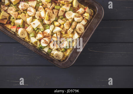 Backform mit rohen Teig und geschnittenen Rhabarber, Apfel und Banane Füllung. Konzept, Entscheidungsprozess Kuchen backen Stockfoto