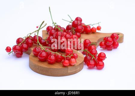 Rote Johannisbeeren auf Schneidebretter und weißem Hintergrund. Stockfoto