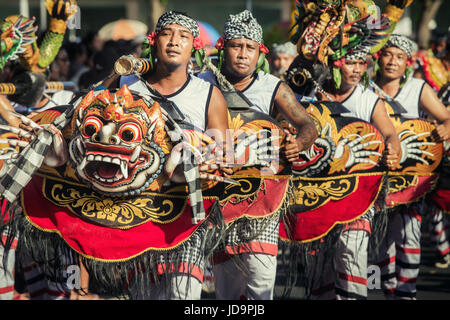 Balinesische Kultur Streetparade während der Eröffnungstag der Bali Arts Festival 2017. Indonesische Männer in einer Prozession mit großer Furcht erregenden balinesischen Masken Stockfoto
