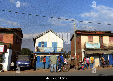 Ein endloser Schwarm Heuschrecken fliegen über die Felder und eine kleine Stadt im zentralen Madagaskar. Stockfoto