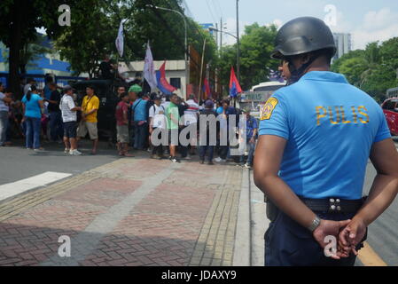 Quezon City, Philippinen. 19. Juni 2017. Ein Polizist ist auf Stand-by, als Demonstranten vor LTO bilden. Bildnachweis: George Buid/Pacific Press/Alamy Live-Nachrichten Stockfoto