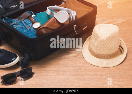 Reisen und Urlaub-Konzept. Öffnen des Reisenden Beutel mit Kleidung und Accessoires. Stockfoto