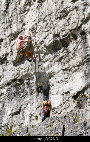 Männliche und weibliche Kletterer Klettern auf Kalkstein Felswand Malham Cove. Malham Malhamdale Yorkshire Dales Nationalpark Yorkshire England UK Stockfoto