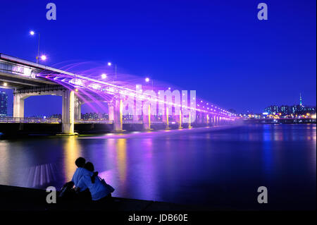 Paar Liebe sitzen an Banpo-Brücke suchen Regenbogen-Brunnen-Show in der Nacht in Seoul, South Korea. Stockfoto