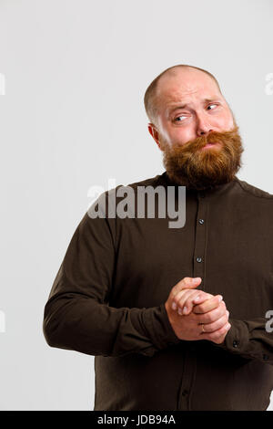 Foto von nachdenklich Glatzkopf in braunen Shirt mit Ingwer Bart mit einem leeren grauen Hintergrund Stockfoto