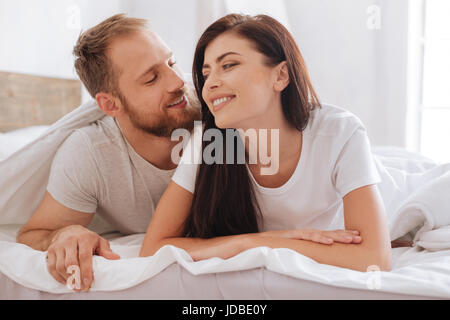 Entzückende junge Paar im Chat im Bett Stockfoto